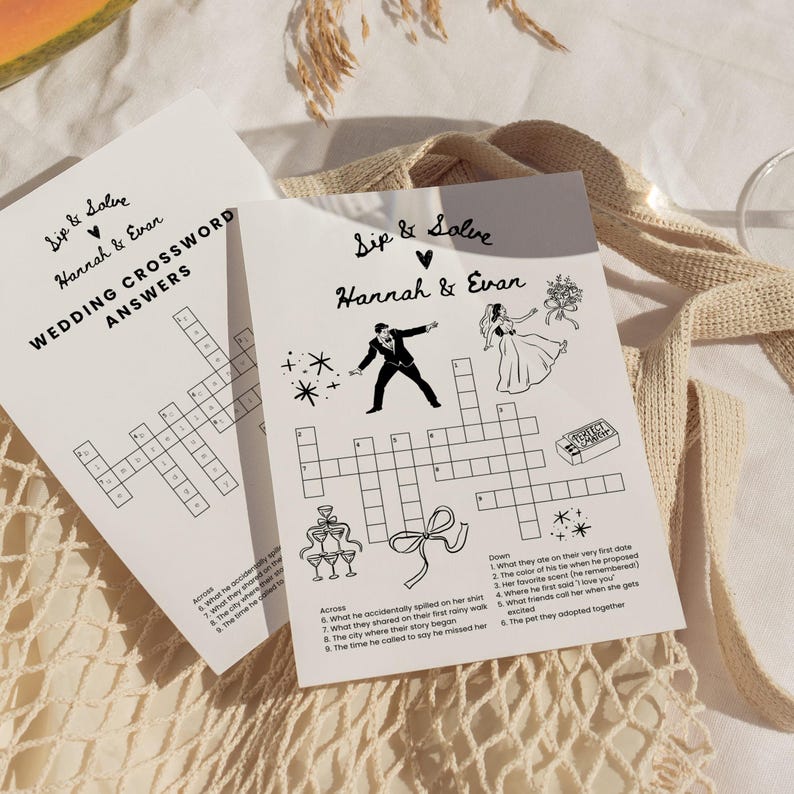 May include: Two white wedding crossword puzzle cards with black text and illustrations. The cards say "Sip & Solve" and "Hannah & Evan." One card says "Wedding Crossword Answers." The other card has a crossword puzzle with wedding-themed clues.