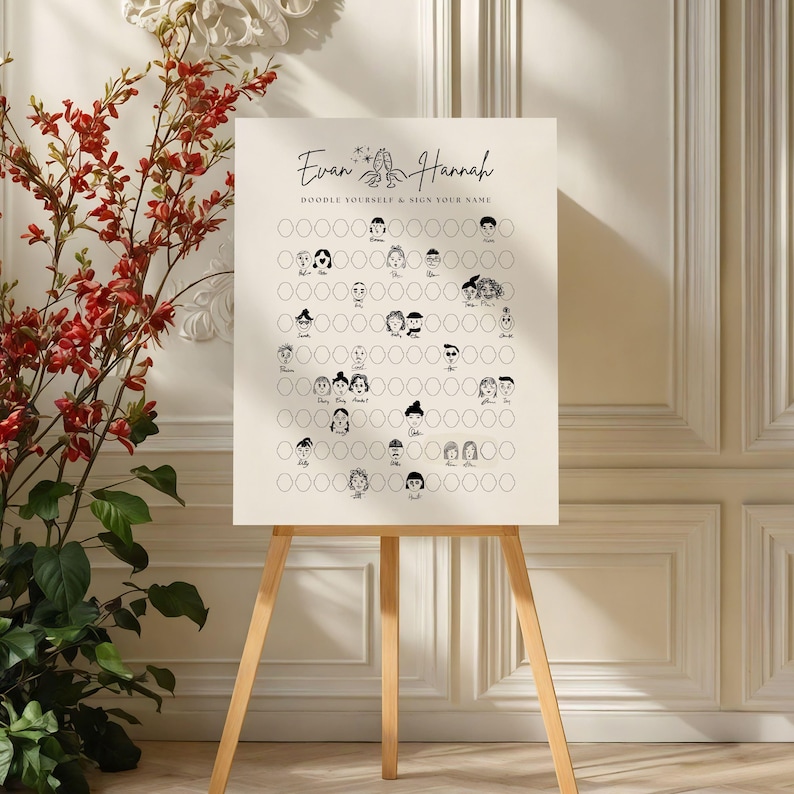 May include: A cream-colored sign on a wooden easel with the names "Evan & Hannah" and the text "DOODLE YOURSELF & SIGN YOUR NAME." The sign features a grid of circles with doodle faces. Red flowers and green leaves are in the background.