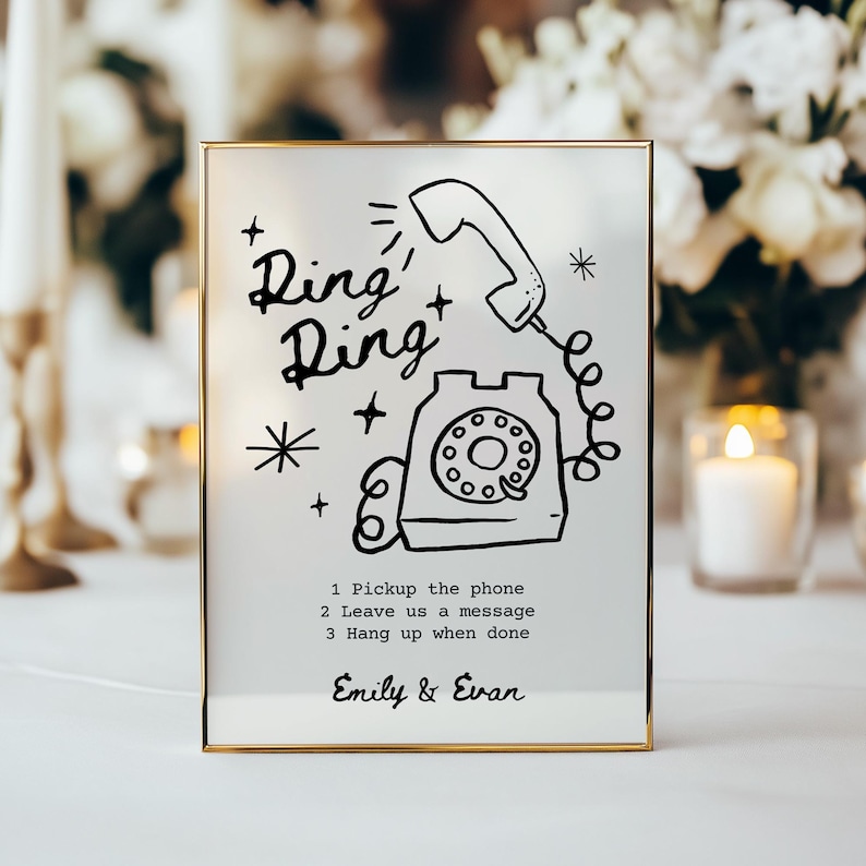 May include: A gold-framed sign with a black and white illustration of a rotary phone with the text "Ring Ring" and instructions to "Pickup the phone, Leave us a message, Hang up when done". The sign is personalized with the names "Emily & Evan".