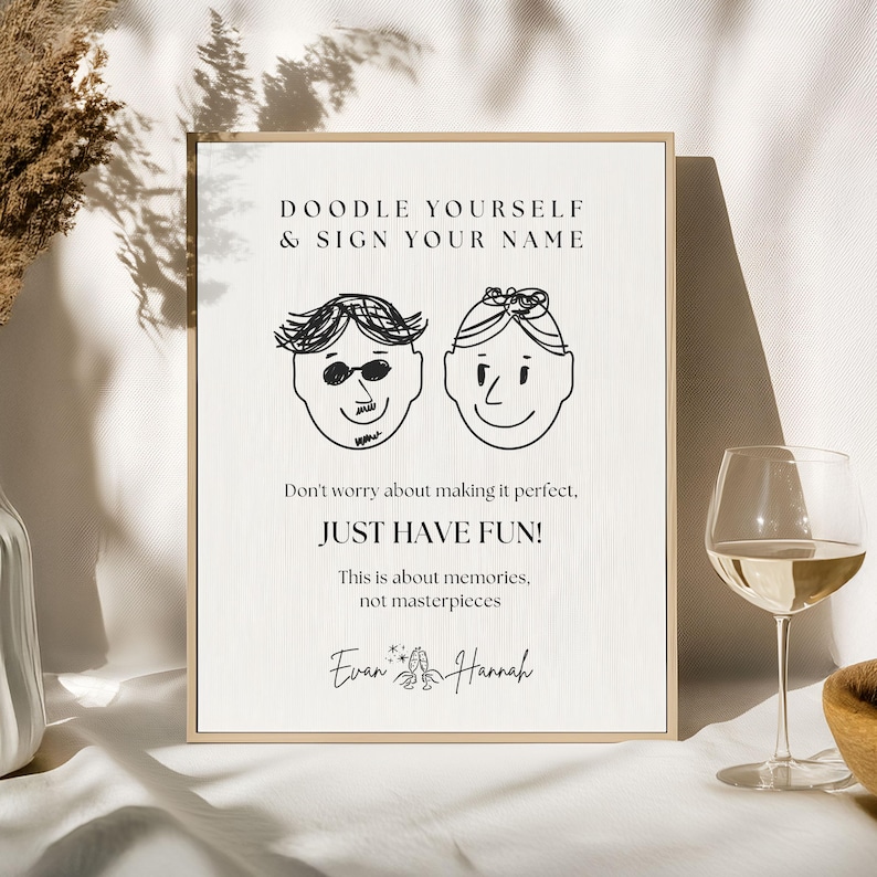 May include: A framed print with the text "DOODLE YOURSELF & SIGN YOUR NAME" and the phrase "JUST HAVE FUN!". The print features two doodle faces and the names "Evan & Hannah" at the bottom.