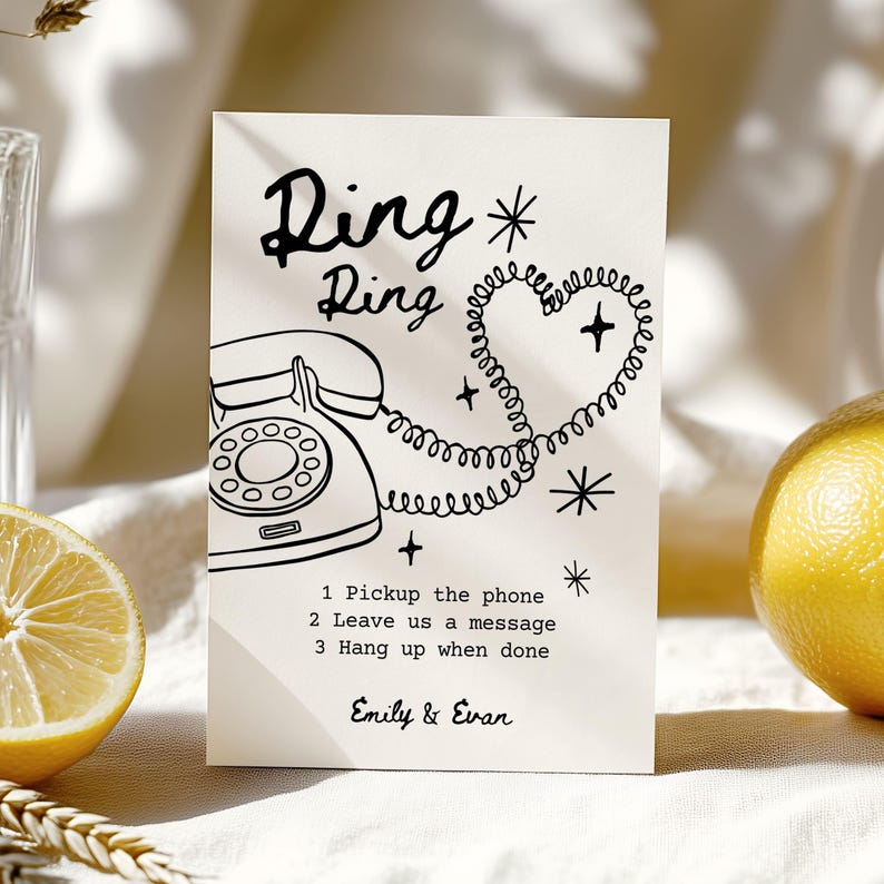 May include: A cream-colored card with a retro phone illustration and the words "Ring Ring." The phone cord forms a heart shape. Text below reads "1 Pickup the phone, 2 Leave us a message, 3 Hang up when done." Names "Emily & Evan" are at the bottom.