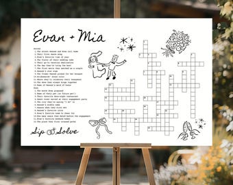 May include: A white wedding crossword puzzle on an easel, featuring the names "Evan + Mia" at the top. The puzzle includes clues and spaces for answers, with decorative illustrations of a couple, flowers, and champagne glasses.