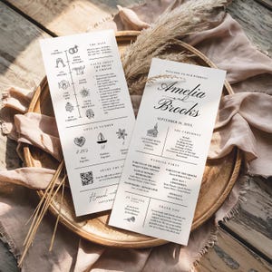 May include: Two white rectangular wedding programme cards with black text and line art illustrations. The cards feature wedding schedules, facts about the couple, a QR code, and the names Amelia and Brooks. The layout includes sections for the ceremony, wedding party, and thank you notes.