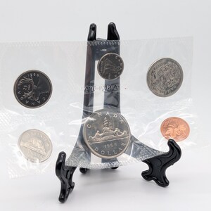 May include: A set of three ceramic mugs with a speckled, matte finish. The mugs are in shades of cream, light brown, and dark brown. Each mug has a simple, minimalist design, perfect for coffee or tea.