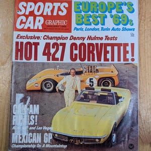 May include: A vintage magazine cover featuring a yellow Corvette and a race car. The headline reads "HOT 427 CORVETTE!" with text about the Mexican GP and Can-Am races. The magazine is titled "SPORTS CAR GRAPHIC" from January 1969.