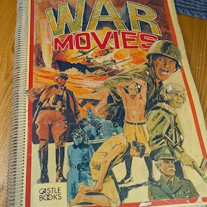 Pode incluir: Um livro de bolso vintage intitulado "War Movies" com uma capa colorida que apresenta um grupo de soldados e uma cena de guerra. A capa também inclui o texto "Castle Books".