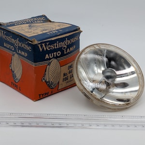 May include: An antique Westinghouse Auto Lamp, Type L, with its original box. The box is blue and orange with the Westinghouse logo and product details. The lamp is silver and glass.