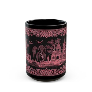 Könnte beinhalten: Schwarze Keramiktasse mit einem rosa-weißen Weidenmuster. Das Muster zeigt eine Pagode, Bäume, Vögel und Menschen.