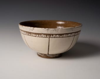 Stoneware bowl with white slip and carved pattern
