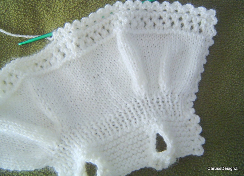 May include: White crocheted baby garment with a scalloped edge.