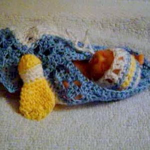 May include: A crocheted baby blanket in blue, white and yellow with a crocheted yellow and white doll attached.