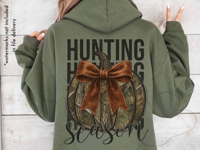 May include: Olive green hoodie with a graphic on the back. The graphic features a pumpkin with a brown bow and camouflage pattern, with the words "HUNTING SEASON" in black.