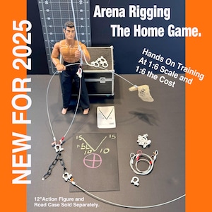 May include: A white action figure is suspended from a silver wire rigging system. The figure is attached to a black suitcase with a white label that reads "Arena Rigging The Home Game." The image also includes a white label with the text "Hands On Training At 1:6 Scale and 1:6 the Cost."