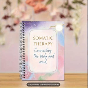 Può includere: Un quaderno a spirale con le parole "SOMATIC THERAPY" e "Connecting the body and mind" sulla copertina. La copertina presenta un design ad acquerello nei toni del viola, rosa e blu. Il quaderno è in formato A5.