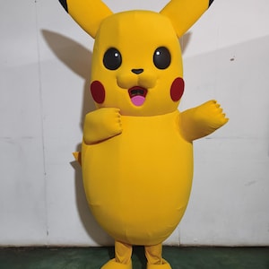 Puede incluir: Un disfraz de mascota Pikachu amarillo con orejas negras, mejillas rojas y boca rosa. El disfraz tiene un cuerpo redondo y piernas amarillas.