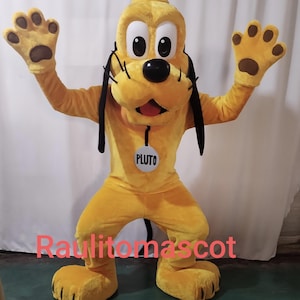 Puede incluir: Un disfraz de mascota de Pluto amarillo con orejas negras y una etiqueta de nombre blanca que dice "Pluto".