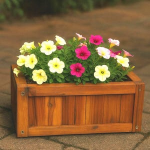 Könnte beinhalten: Eine rechteckige Blumenkasten aus Holz, gefüllt mit leuchtenden Blumen. Die Blumen sind eine Mischung aus Gelb, Rosa und Weiß, mit grünem Laub. Der Pflanzkasten ist aus gebeiztem Holz und steht auf einer Ziegeloberfläche.