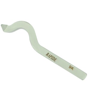 May include: A light green, curved tool with the word "RAPIDE" printed on the side. The tool has a hook-like shape on one end and the number "9K" is printed on the other end. The tool is made of a solid, opaque material.