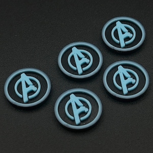 Könnte beinhalten: Sechs runde, blaue und schwarze Plastikmarken mit dem Avengers-Logo darauf gedruckt.