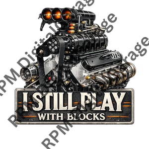 May include: A detailed illustration of a black engine with chrome accents. The engine features a belt, multiple cylinders, and the text "I STILL PLAY WITH BLOCKS" on a rectangular sign.