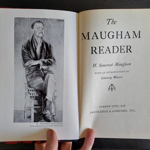 May include: A black and white photo of W. Somerset Maugham, the author of the book "The Maugham Reader". The book cover features the title in bold, black font, and the author's name in smaller, black font. The book was published by Doubleday & Company, Inc. in Garden City, New York.
