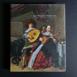 May include: Book cover featuring a painting of two people playing stringed instruments. The text "Jan Miense Molenaer, Painter of the Dutch Golden Age" is at the top. The North Carolina Museum of Art logo is at the bottom.