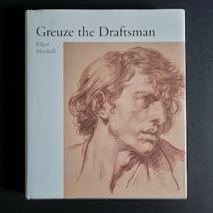 May include: A hardcover book titled Greuze the Draftsman by Edgar Munhall. The white cover features a large, detailed sepia-toned ink drawing of a person's head and shoulders, rendered with expressive, visible lines on a light tan background.
