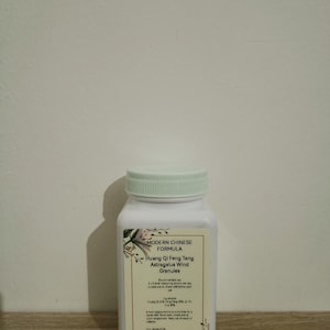 Op de afbeelding: Een witte plastic fles met een lichtgroene deksel. Het etiket luidt "MODERN CHINESE FORMULA" en "Huang Qi Feng Tang Astragalus Wind Granules". De fles bevat een wit poeder. Het nettogewicht is 100g.
