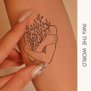 May include: A line drawing tattoo design of a person embracing themself with flowers growing from their body.