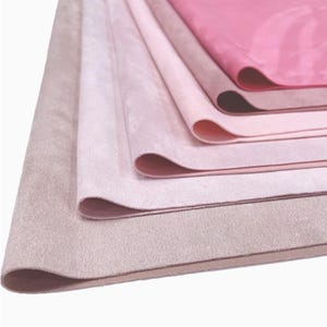 May include: A stack of five different shades of pink fabric swatches. The fabric is soft and velvety, with a subtle sheen.