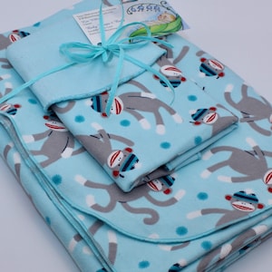 May include: A set of four baby blankets in a blue and gray monkey print. The blankets are made of soft, comfortable fabric and are perfect for cuddling.
