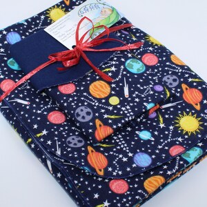 May include: A set of three blue fabric baby burp cloths with a space-themed print featuring planets, stars, and comets. The cloths are folded and tied together with a red ribbon.