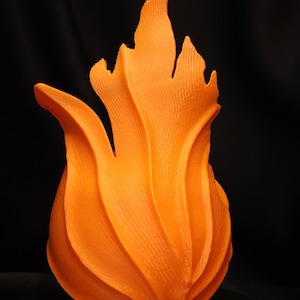 May include: A vibrant orange, flame-shaped sculpture with textured details. The sculpture has a rounded base and a series of upward-curving, flame-like forms. The background is a solid black, which highlights the sculpture's bright color and unique shape.