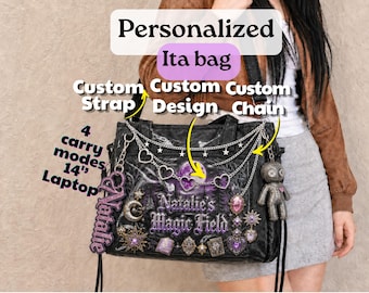 May include: A black ita bag featuring a purple moon and forest graphic with the text Natalie's Magic Field. The bag includes silver chains with heart and star charms, a dangling Natalie name tag, a voodoo doll charm, and four carry modes.