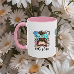 Op de afbeelding: Witte keramische mok met een roze binnenkant en oor. De mok heeft een afbeelding van een vrouw met een turquoise hoofddoek, bril en medische benodigdheden. De tekst "#Nurselife" staat eronder.