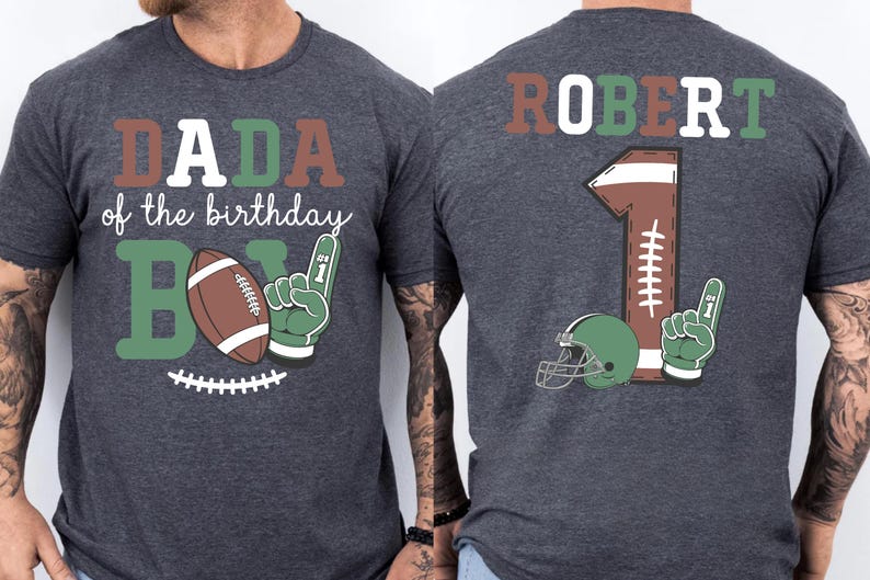 two gray t-shirts with a graphic design on the back. The design includes a football, a number 1, and the text "DADA of the birthday B" and "ROBERT 1".