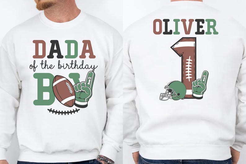 A white sweatshirt with a graphic design featuring a football and the text "DADA of the birthday" and "OLIVER 1" printed on it.