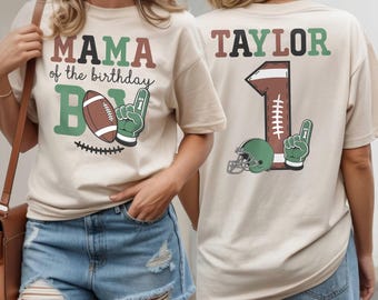 May include: Beige t-shirts with football-themed graphics. One shirt reads "MAMA of the birthday BOY" with a football and foam finger. The other shirt has "TAYLOR" and a football-shaped "1" with a helmet and foam finger.