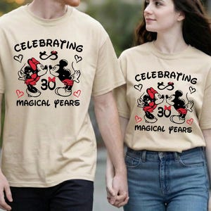 Couple smiling at each other while wearing coordinated Disney Disneyland hoodies with a 30 Magical Years milestone message. The romantic cartoon style graphic adds charm and nostalgia, making it a perfect Disney anniversary celebration outfit.