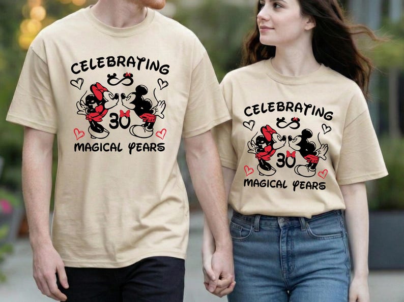 Couple smiling at each other while wearing coordinated Disney Disneyland hoodies with a 30 Magical Years milestone message. The romantic cartoon style graphic adds charm and nostalgia, making it a perfect Disney anniversary celebration outfit.