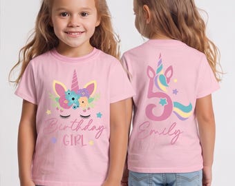 May include: Pink short-sleeved t-shirt with a unicorn design. The front features a unicorn face with floral accents and the text "Birthday Girl". The back displays a number 5 and the name "Emily".