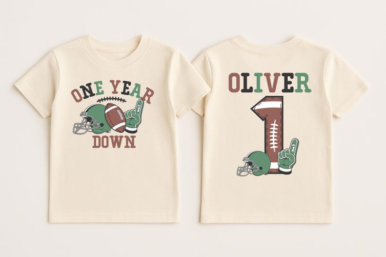 two white t-shirts with a football and a helmet printed on them, along with the text "One Year Down" and the name "Olivier" printed on the back.