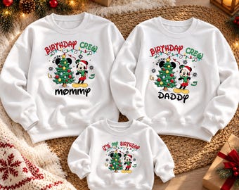 May include: Three white long-sleeve sweatshirts featuring a Christmas-themed graphic with a decorated tree, a cartoon mouse in a Santa hat, and string lights. The text reads Birthday Crew Mommy, Birthday Crew Daddy, and It's My Birthday.