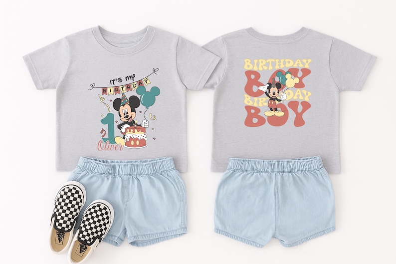 a pair of children's clothing items, including a gray t-shirt with a Mickey Mouse design and a pair of denim shorts, along with a pair of black and white checkered shoes.