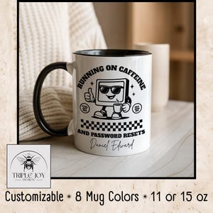 Puede incluir: Taza de cerámica blanca con asa y borde negros, con el texto "RUNNING ON CAFFEINE AND PASSWORD RESETS" y un personaje de dibujos animados de ordenador. La taza está disponible en 8 colores y en tamaños de 312 o 425 ml.