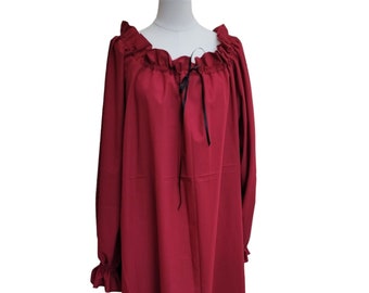 May include: A long-sleeved, burgundy dress with a ruffled neckline and a black ribbon tie. The dress has long sleeves with ruffles at the cuffs.