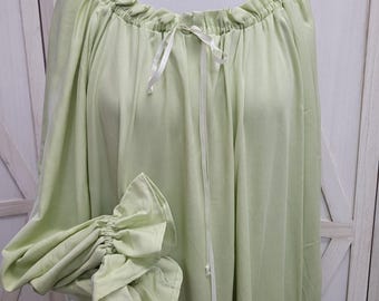 May include: A light green, long-sleeved garment with a gathered neckline and cuffs. A white ribbon is tied at the neckline. The sleeves are gathered at the wrist, creating a ruffled effect. The fabric appears soft and flowing.