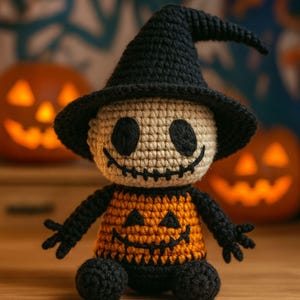 Puede incluir: Muñeca de Halloween de ganchillo con diseño de calabaza. La muñeca tiene una cabeza beige con ojos negros y una sonrisa cosida, un sombrero de bruja negro y un cuerpo naranja con una cara de calabaza tallada. Brazos y piernas negros.