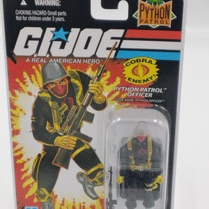 May include: A G.I. Joe Python Patrol Officer action figure in its original packaging. The card features a red, black, and yellow illustration of the character. The figure is in a clear plastic case. The packaging reads "A Real American Hero."