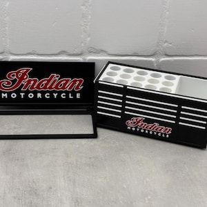 May include: Black desk organizer with the words "Indian MOTORCYCLE" in red and white. The organizer has a section for pens and pencils and a separate section for other items. A matching black sign is also included.